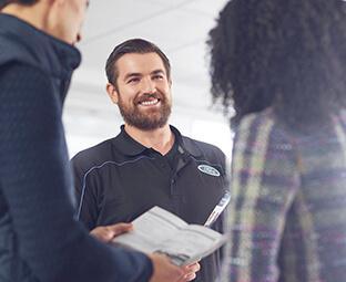 Ford service man helping clients